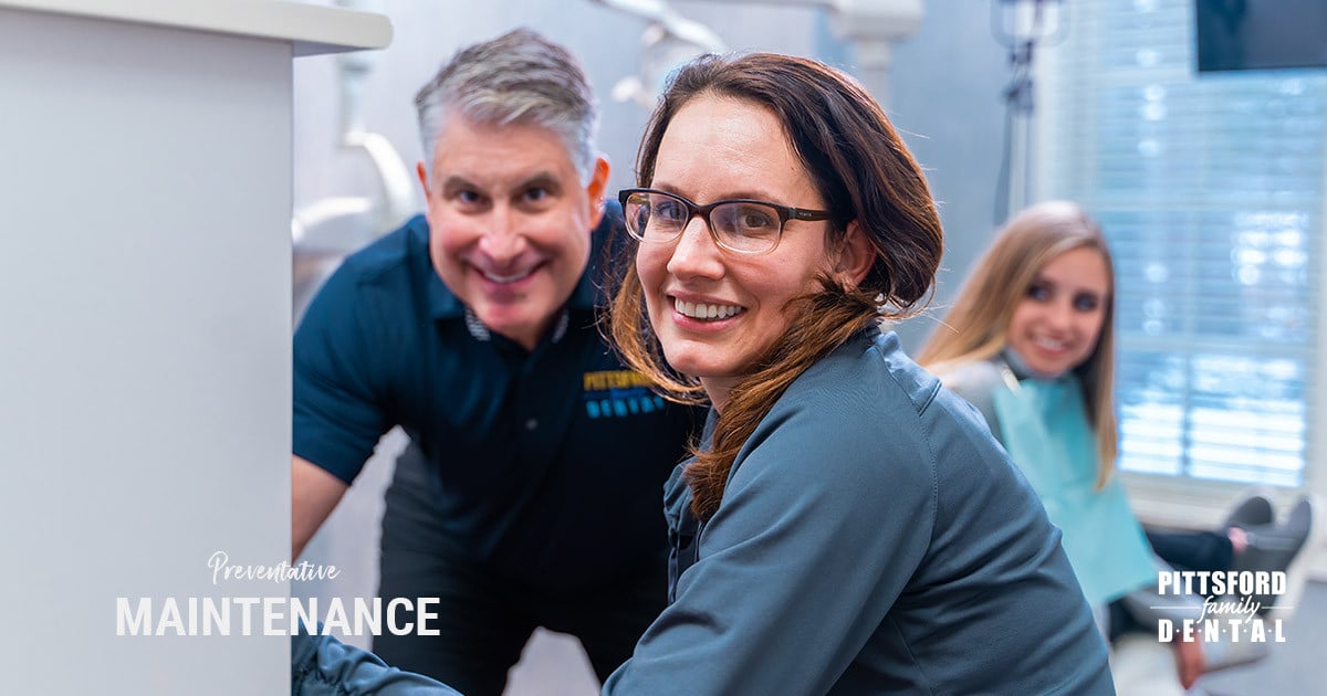 Smiling dental team members in modern clinical setting at Pittsford Family Dental office.
