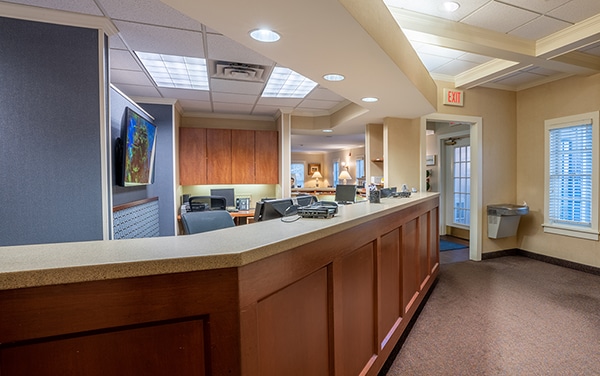 Reception desk in modern dental office with waiting area and professional interior design.