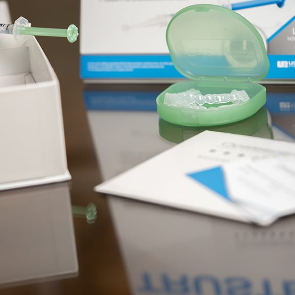 Green dental supplies and instruments arranged on a dental office desk with paperwork.