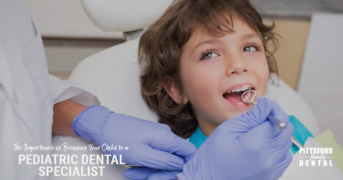 Young child receiving dental examination from dentist wearing blue gloves in clinical setting.