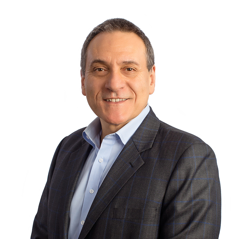 Professional headshot of a smiling man in business attire against white background.