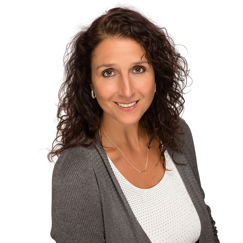 Professional headshot of a woman smiling at camera against white background, wearing gray cardigan.