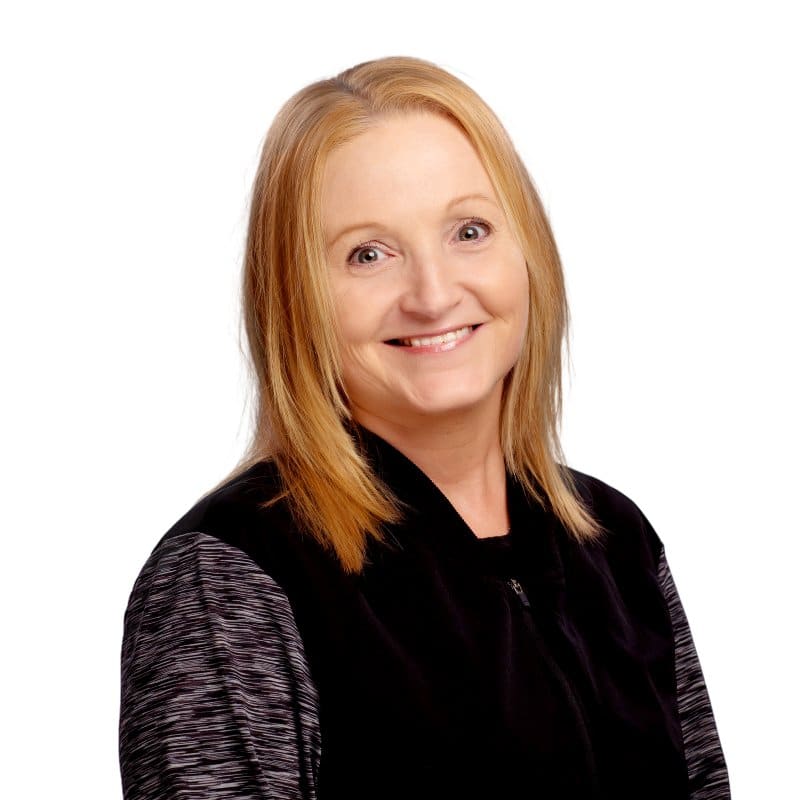 Professional headshot of a smiling woman with reddish-brown hair against a white background.