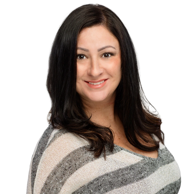 Professional headshot of woman smiling at camera against white background, wearing striped gray sweater.